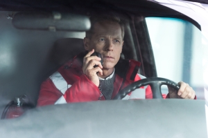 Male ambulance driver using a radio